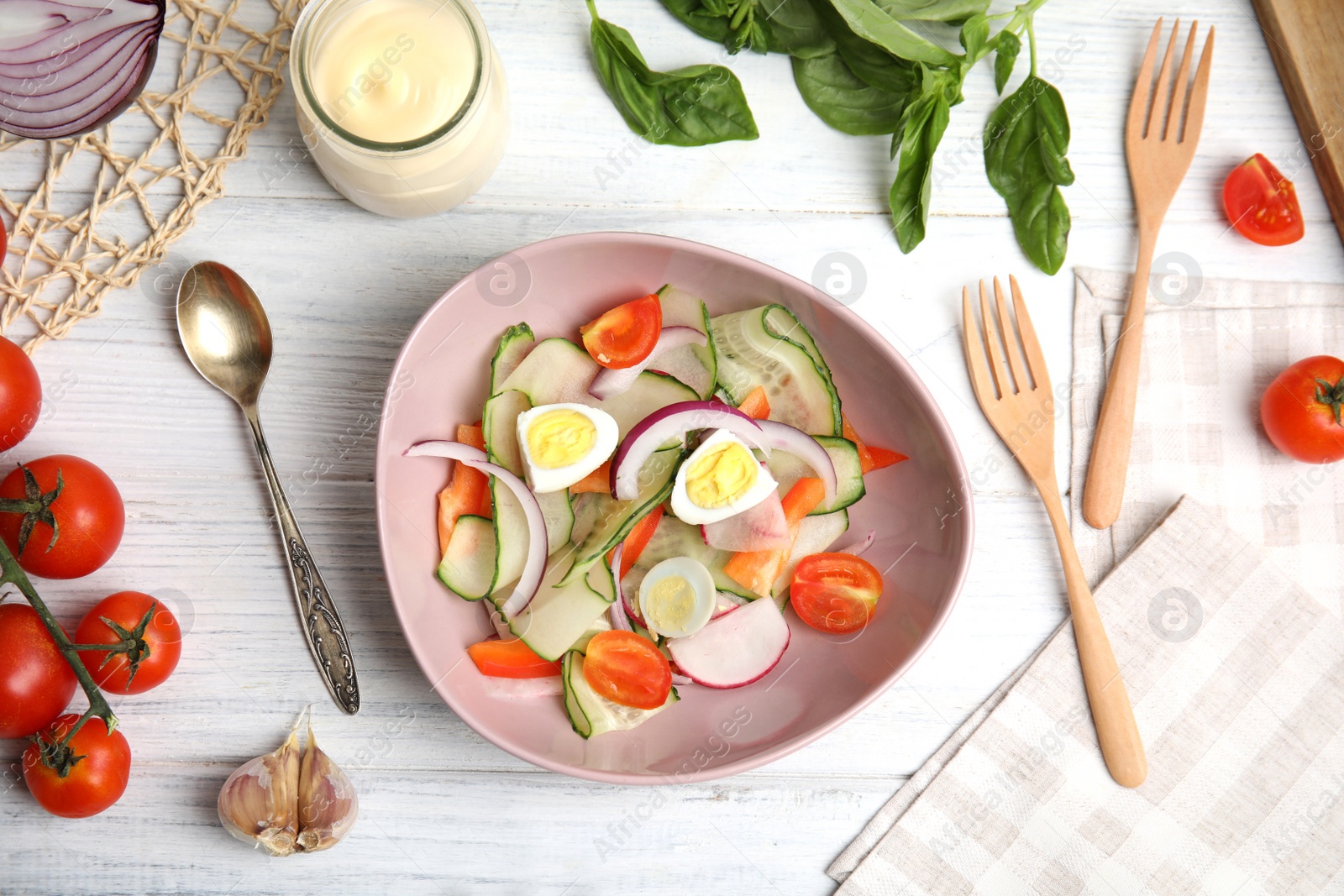 Photo of Bowl of delicious salad with mayonnaise and other ingredients on white wooden table, flat lay