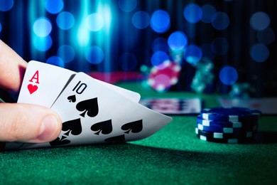 Image of Man playing poker at table with casino chips, closeup