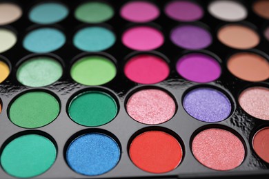 Photo of Beautiful eyeshadow palette as background, closeup. Professional cosmetic product