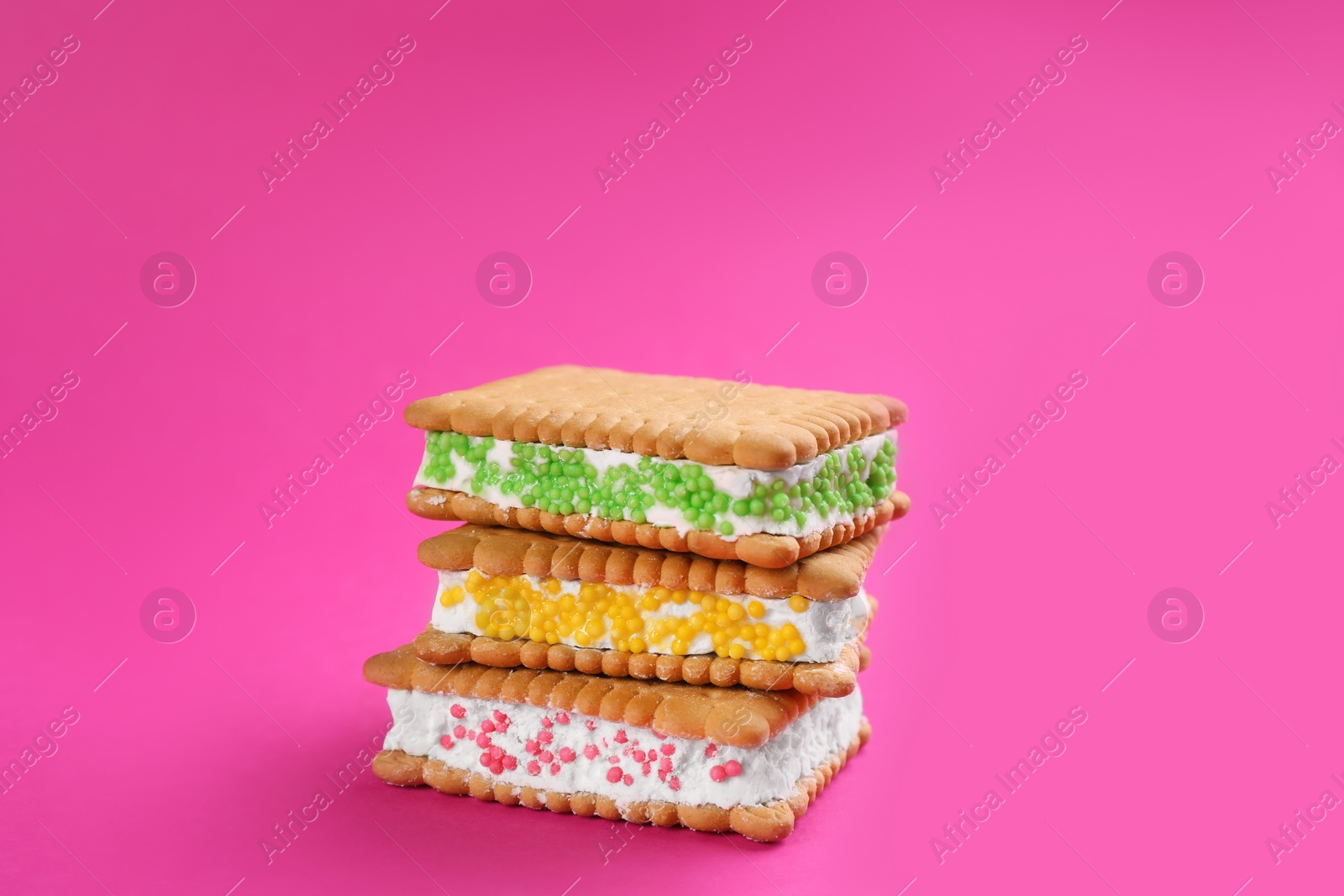 Photo of Sweet delicious ice cream cookie sandwiches on pink background