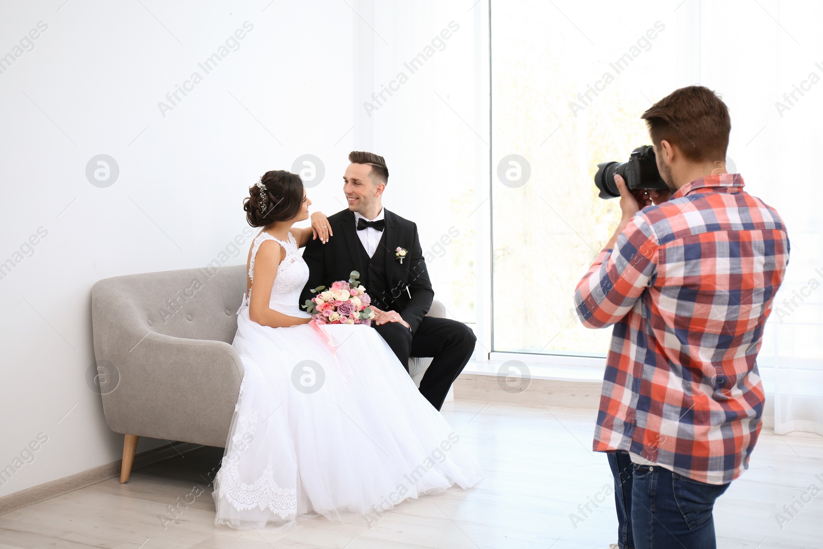 Photo of Professional photographer taking photo of wedding couple in studio