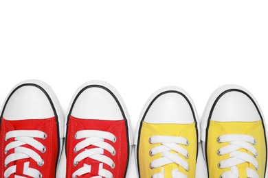 Photo of Yellow and red classic old school sneakers isolated on white, top view