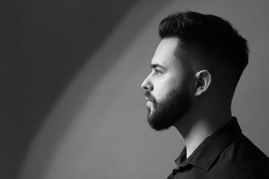 Photo of Portrait of handsome bearded man on grey background, space for text. Black and white effect