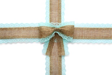 Photo of Burlap ribbons and bow with light blue lace on white background, top view