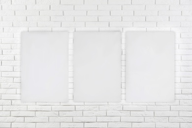 Image of Blank poster on white brick wall. Mockup for design 