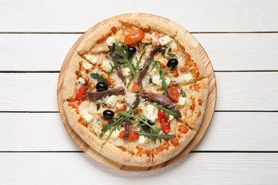 Photo of Tasty pizza with anchovies, arugula and olives on white wooden table, top view