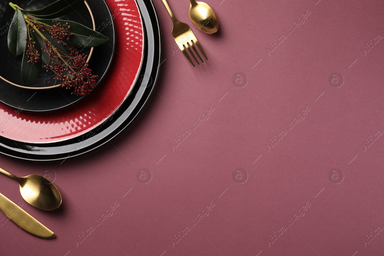 Photo of Stylish table setting with cutlery and floral decor on pink background, flat lay. Space for text