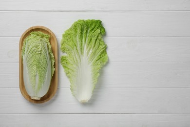 Photo of Fresh ripe Chinese cabbage and leaf on white wooden table, flat lay. Space for text