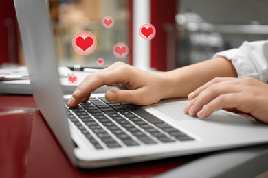 Young woman using laptop in cafe, closeup. Social media