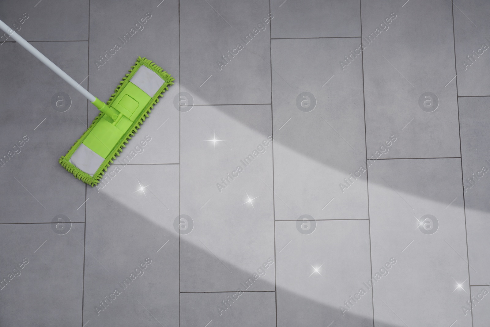 Image of Washing floor with mop indoors, top view. Clean and shiny trace on dirty surface