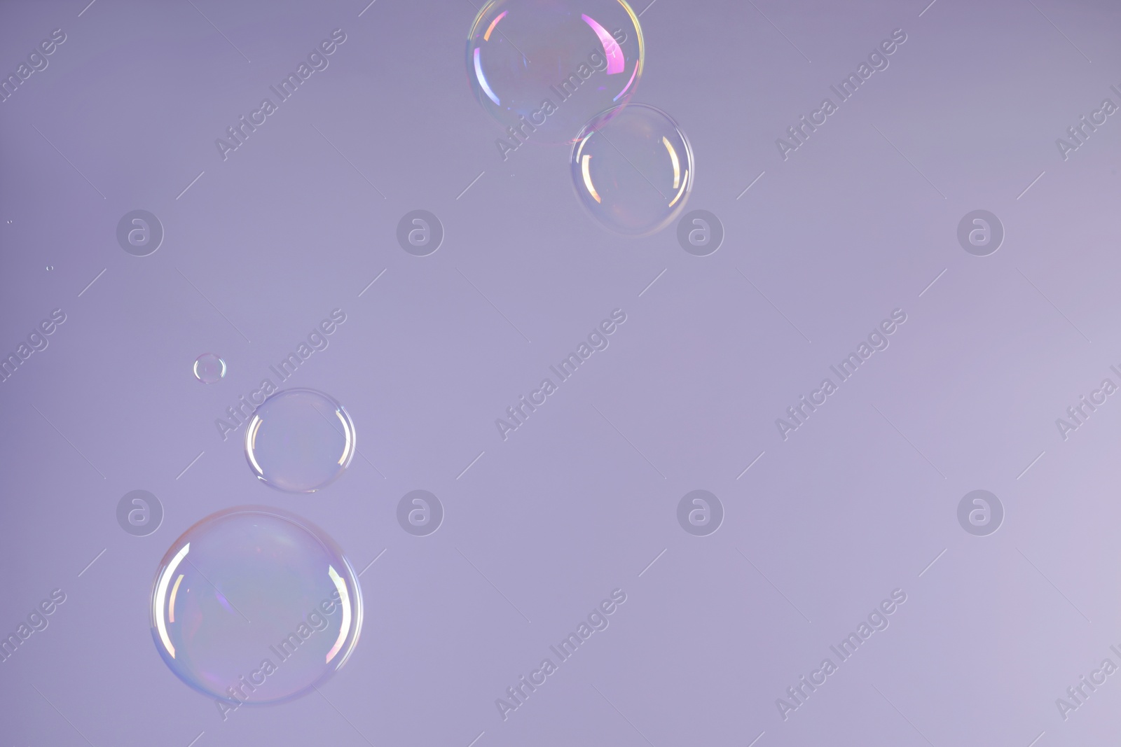 Photo of Many beautiful soap bubbles on light grey background. Space for text