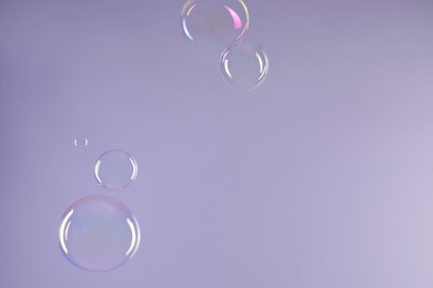 Photo of Many beautiful soap bubbles on light grey background. Space for text