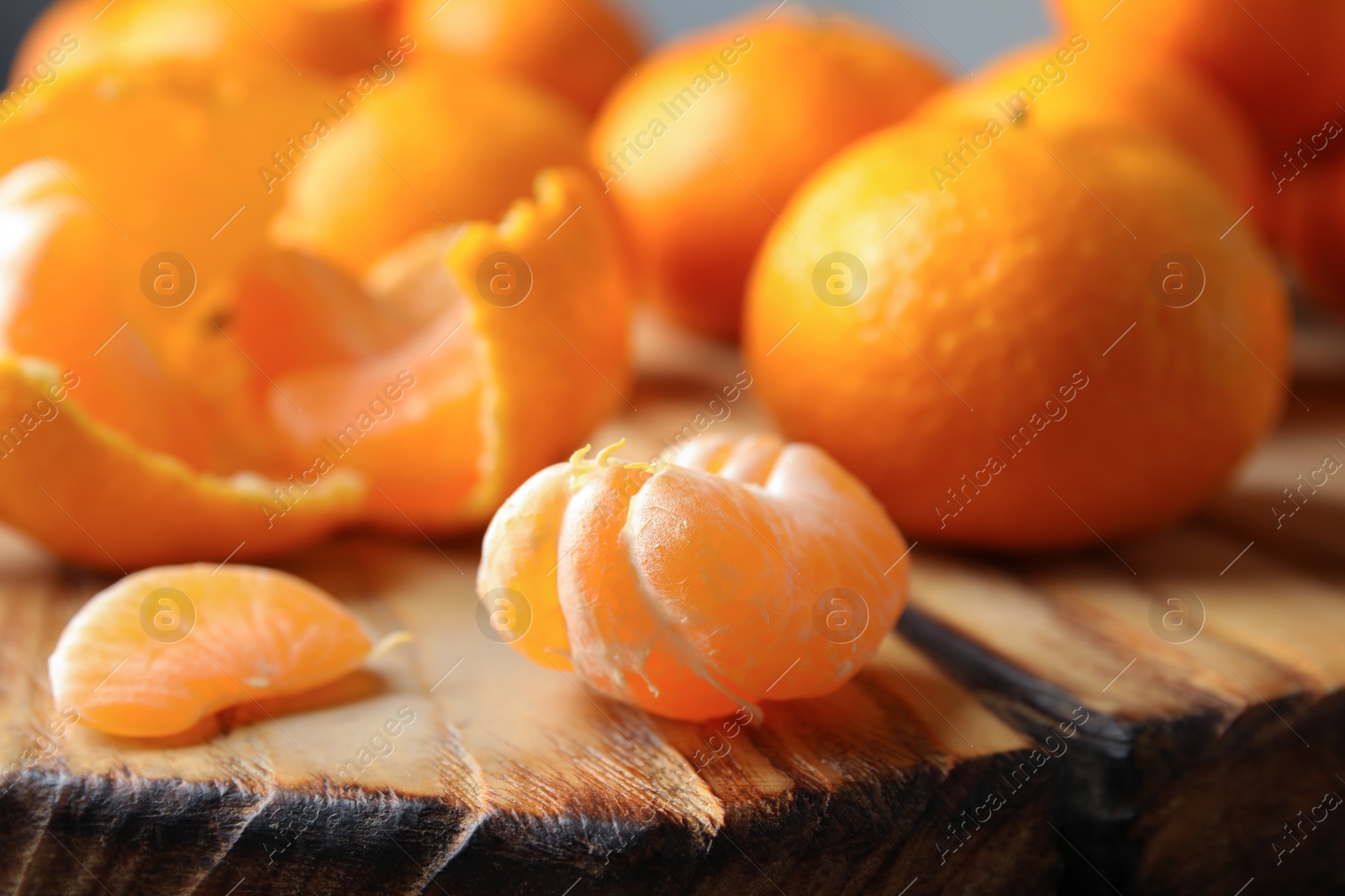 Photo of Wooden board with ripe tangerines, closeup view