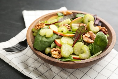 Photo of Delicious fresh celery salad on black table, closeup