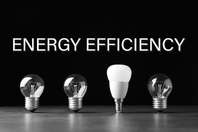 Image of Energy efficiency concept. Incandescent and LED lamp bulbs on grey table