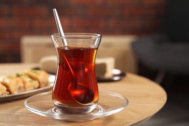 Photo of Traditional Turkish tea in glass on wooden table. Space for text