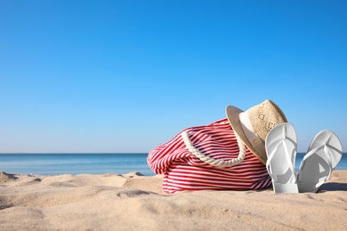 Set with stylish beach accessories on sand near sea