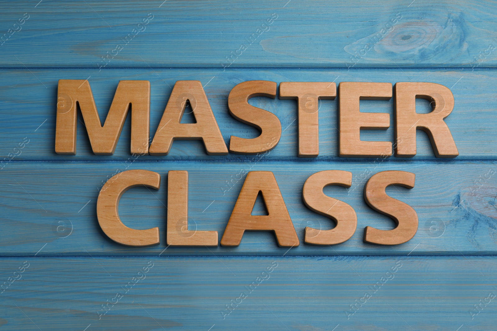 Photo of Words Master Class made of wooden letters on light blue table, flat lay