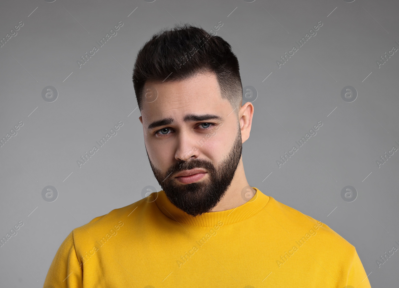 Photo of Portrait of sad man on light grey background