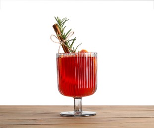 Photo of Christmas Sangria cocktail in glass on wooden table against white background