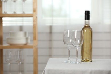 Photo of Bottle of wine with two glasses on table indoors