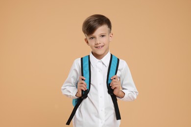 Photo of Back to school. Cute boy with backpack on beige background