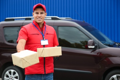 Photo of Courier with packages near car outdoors, space for text