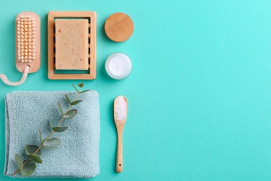 Photo of Jar of cream, body care products and eucalyptus branch on turquoise background, flat lay. Space for text