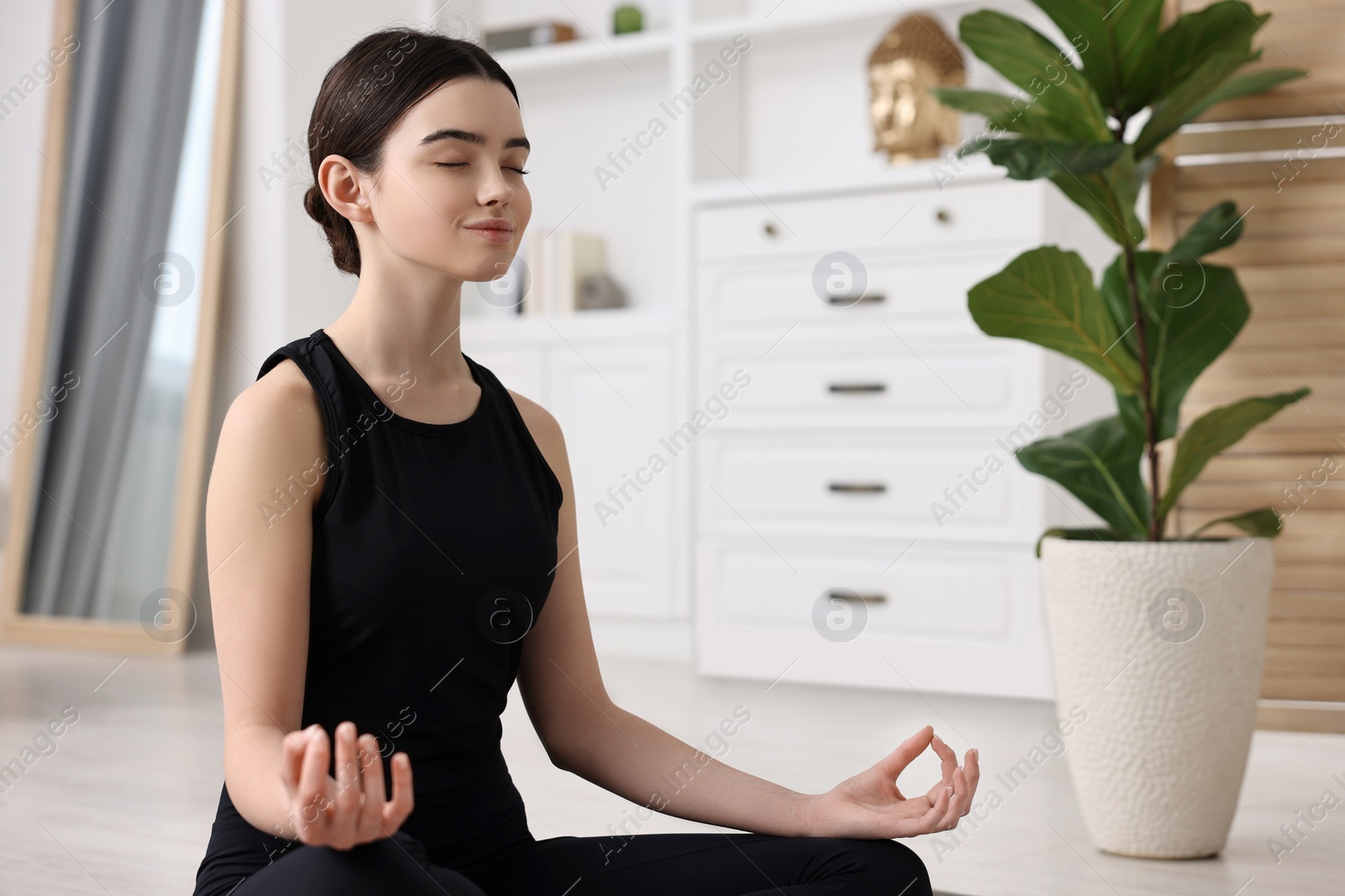 Photo of Beautiful girl meditating at home. Practicing yoga