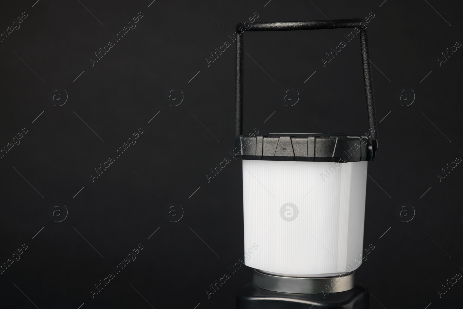 Photo of Camping lantern on black background, closeup with space for text. Military training equipment