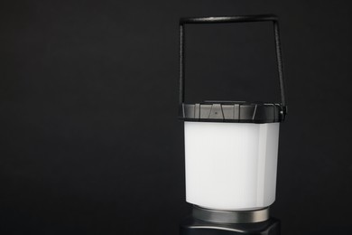 Photo of Camping lantern on black background, closeup with space for text. Military training equipment