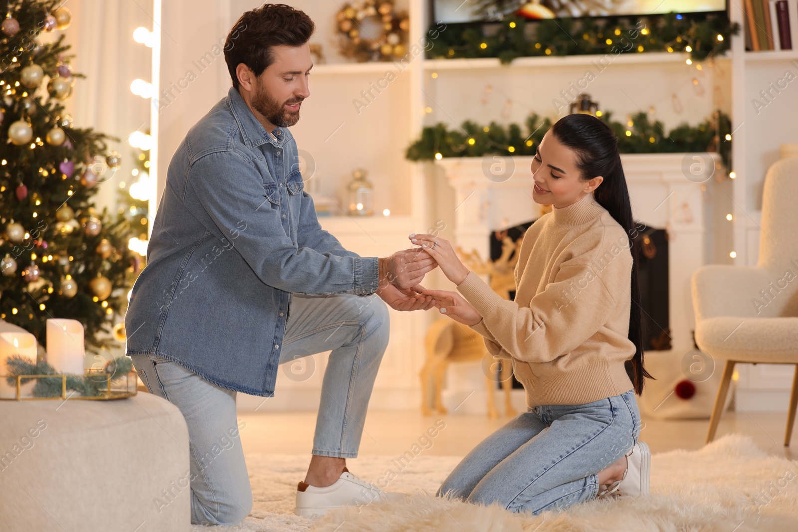 Photo of Man with engagement ring making proposal to his girlfriend at home on Christmas