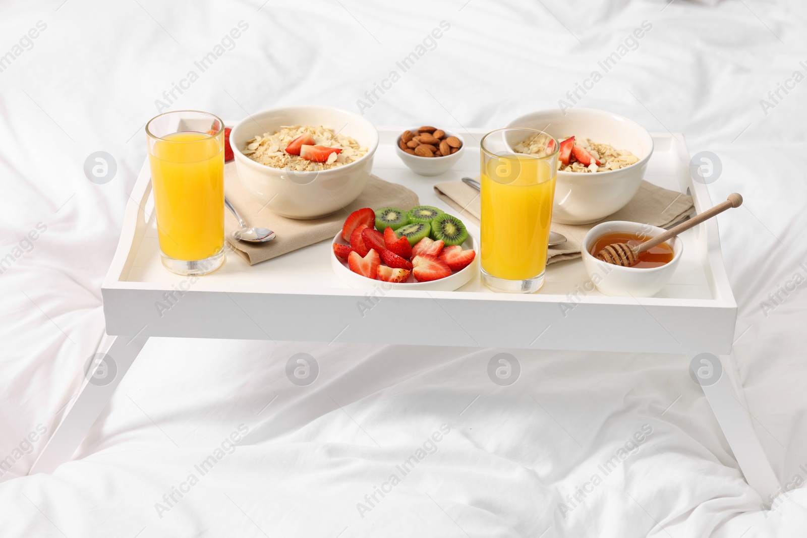 White tray with tasty breakfast on bed Photo of White tray with tasty breakfast on bed