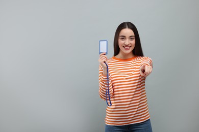 Photo of Happy woman with vip pass badge on grey background. Space for text