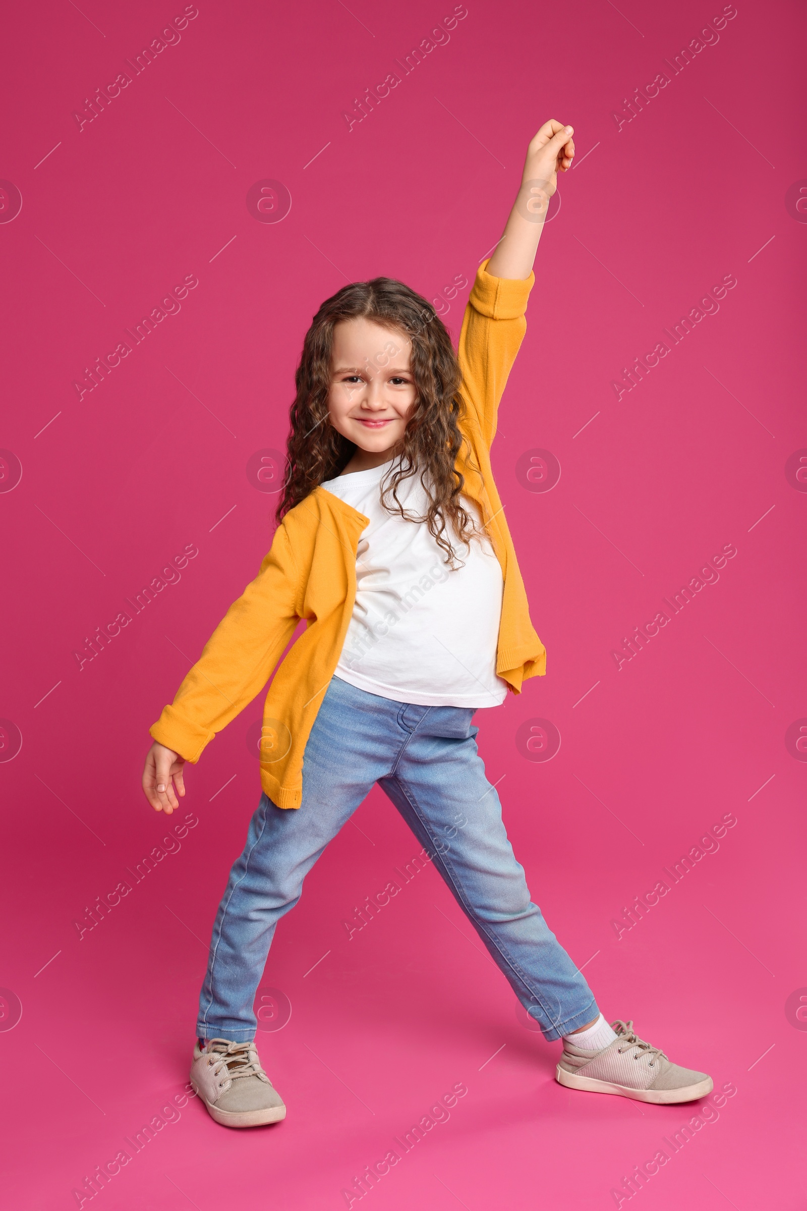Photo of Full length portrait of cute little girl on pink background