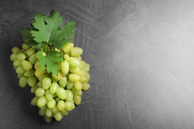 Photo of Fresh ripe juicy grapes on grey table, top view. Space for text