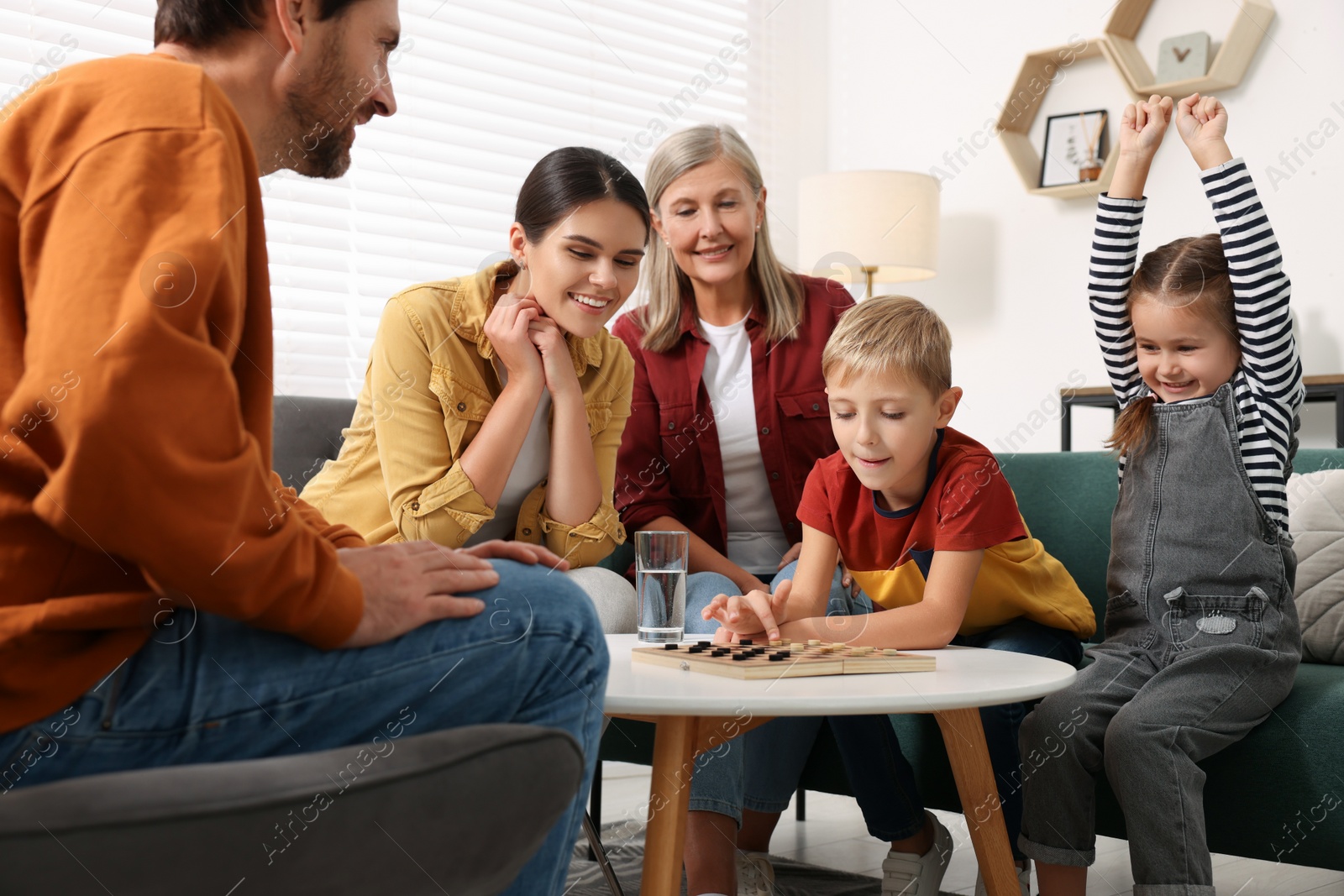 Photo of Family playing checkers at coffee table in room