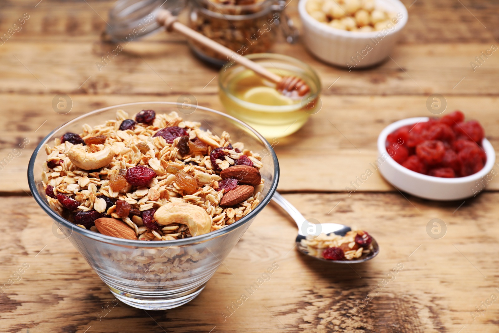 Photo of Tasty granola served with nuts and dry fruits on wooden table