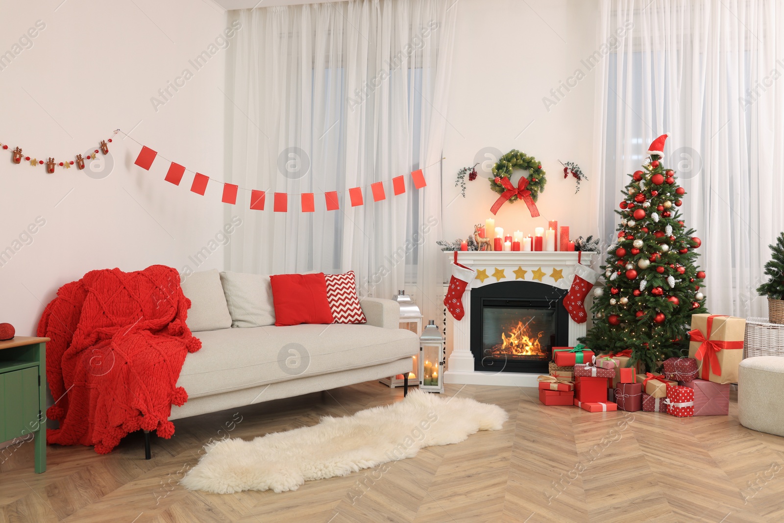 Photo of Festively decorated room with Christmas tree, gift boxes, fireplace and sofa. Interior design