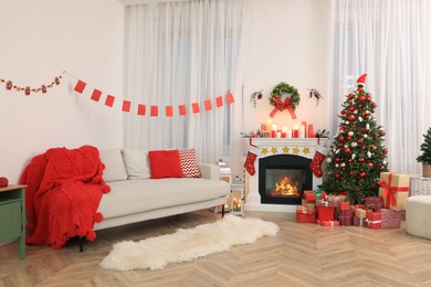 Photo of Festively decorated room with Christmas tree, gift boxes, fireplace and sofa. Interior design