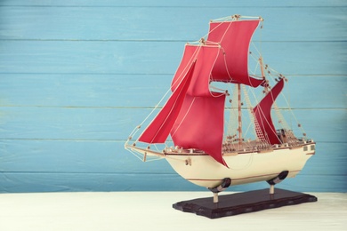 Photo of Beautiful ship model on white wooden table. Space for text