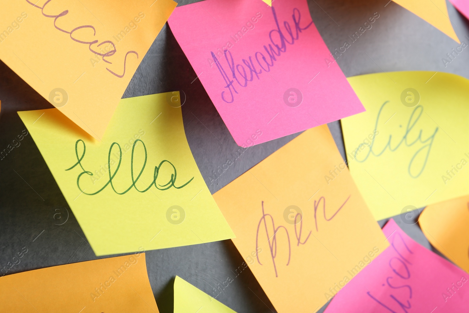 Photo of Paper notes with different baby names on grey wall