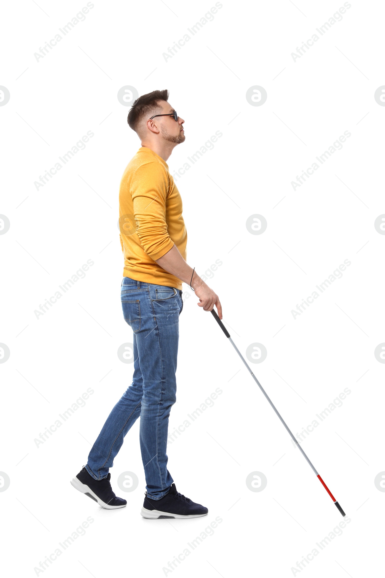 Photo of Blind man in dark glasses with walking cane on white background