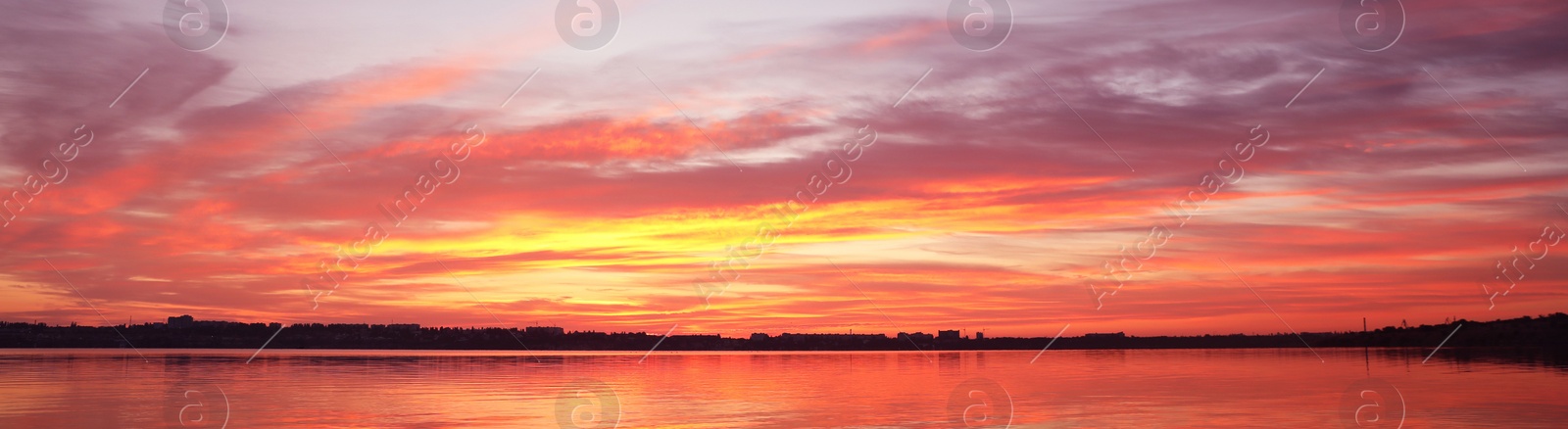 Image of Beautiful sky over river at sunset, banner design