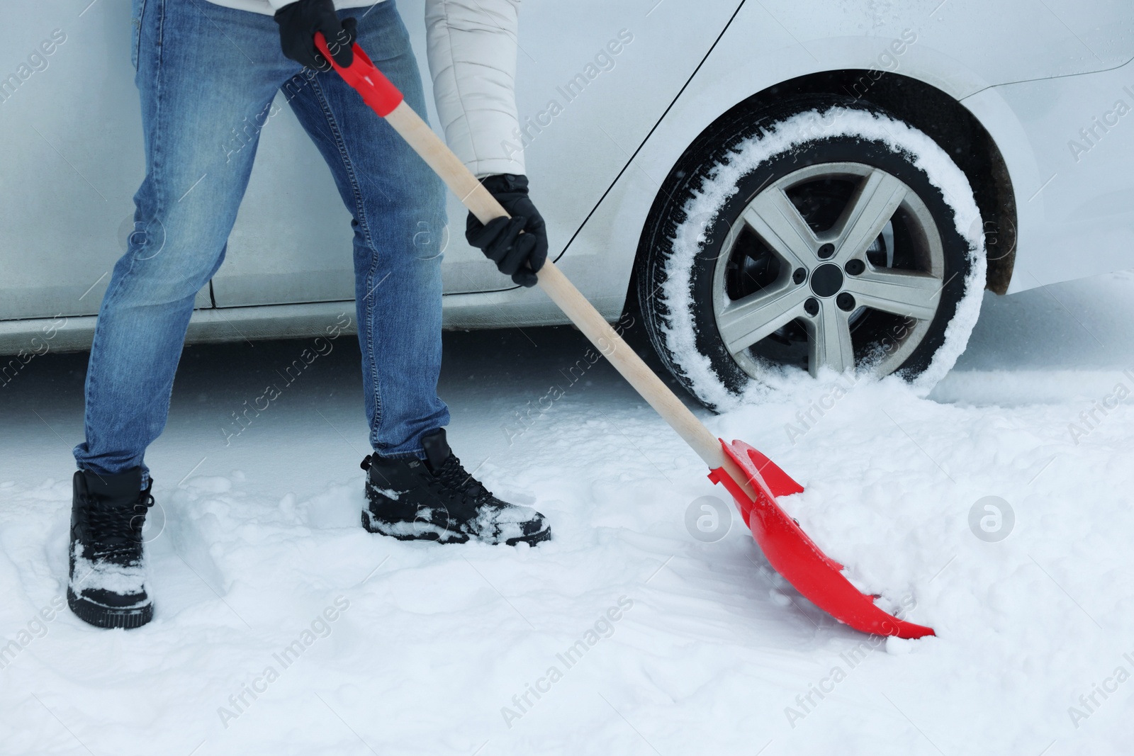 Photo of Man removing snow with shovel near car outdoors, closeup