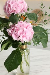 Photo of Beautiful pink hortensia flowers in vase indoors, closeup