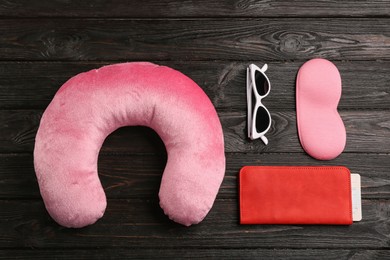 Flat lay composition with pink travel pillow on wooden background