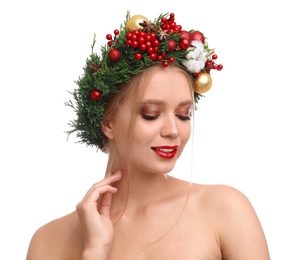 Beautiful young woman wearing Christmas wreath on white background