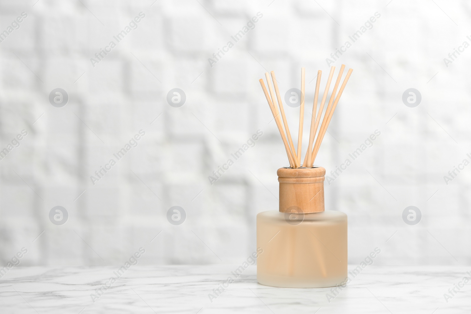 Photo of Aromatic reed freshener on table against light background