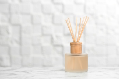 Photo of Aromatic reed freshener on table against light background